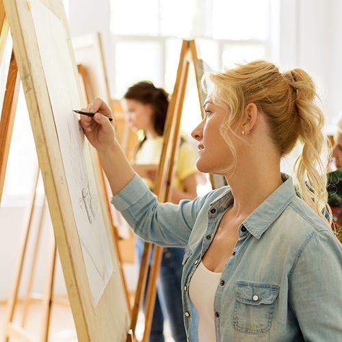 Frau mit Staffelei beim Zeichnen im Atelier einer Kunstschule