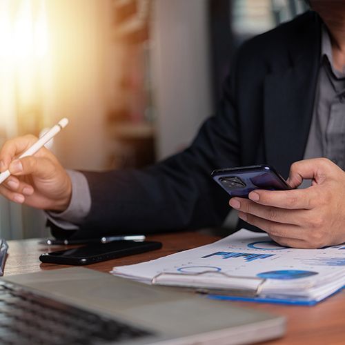 Ein Mann h&auml;lt ein Handy in der Hand.