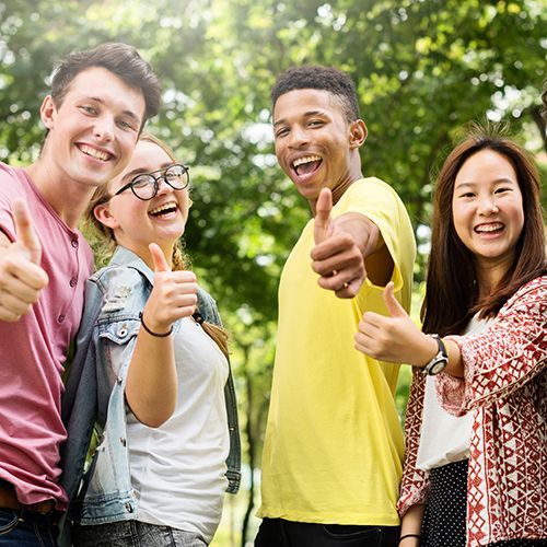 Gut gelaunte junge Menschen zeigen "Daumen hoch".