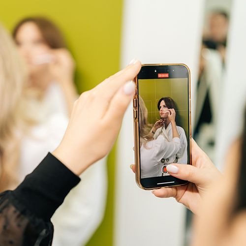 Eine Person fotografiert eine Frau.