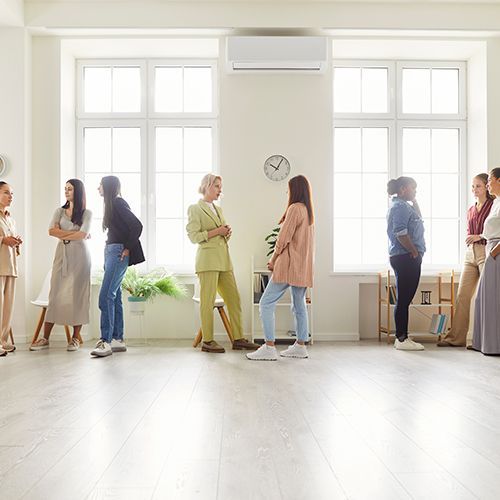 Mehrere Frauen in einem Raum unterhalten sich.
