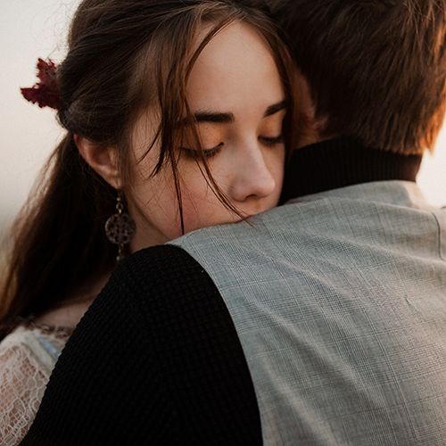 Ein junges Paar umarmt sich. Sie scheinen um jemanden zu trauern.