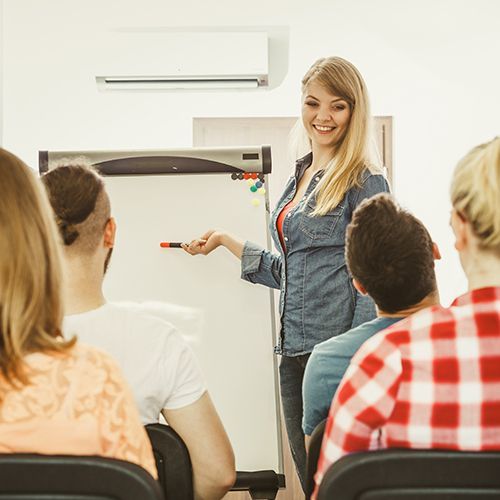 Eine Dozierende die Kunden und Kundinnen etwas erkl&auml;rt.