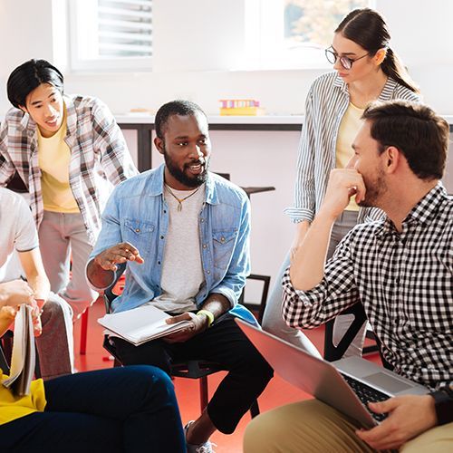 Eine Gruppe von f&uuml;nf Kursteilnehmenden bespricht ihr Projekt