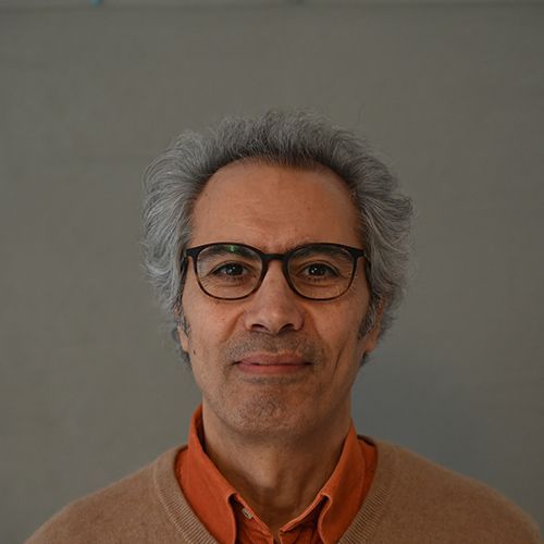 Ein Mann schaut in eine Kamera.