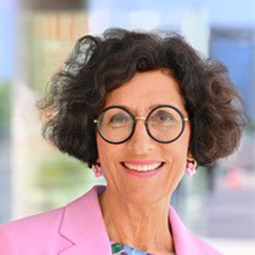Eine Frau mit Brille und rosa Blazer