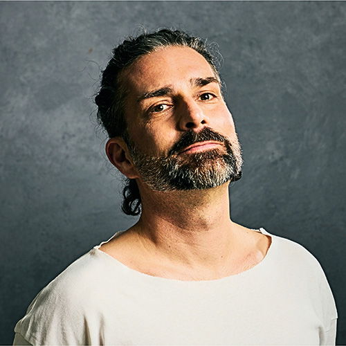 Dozent mit dunklem grau melierten Haar und Bart