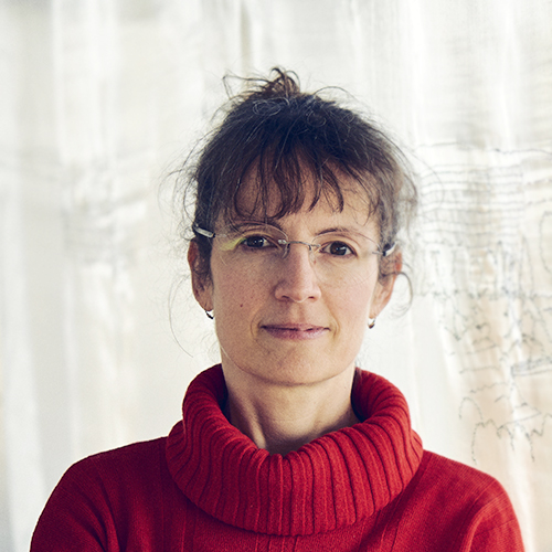 Dozentin mit Brille und rotem Pullover