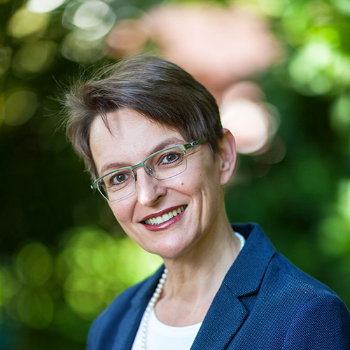 Portrait einer Dozentin mit kurzen dunklen Haaren und Brille.